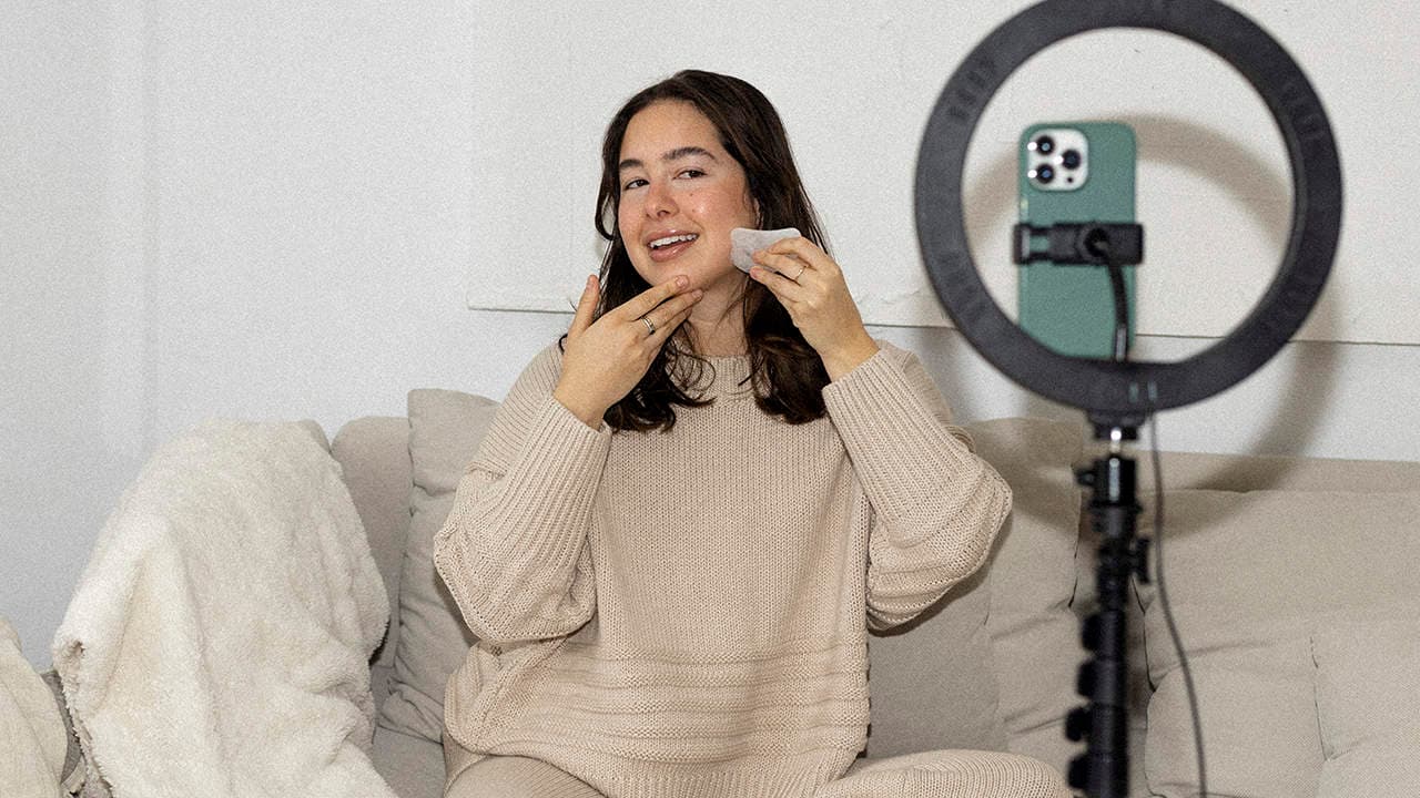 A UGC creator filming an authentic product video with natural window lighting on a phone
